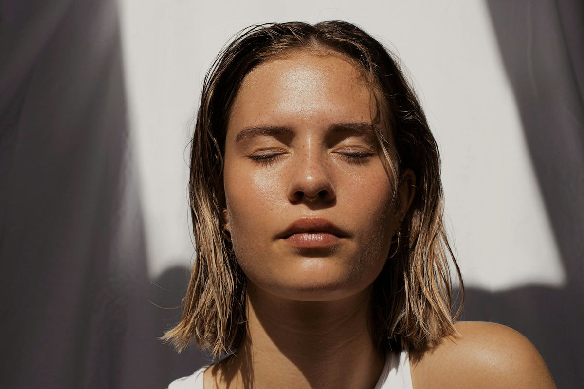 Mujer con piel radiante y ojos cerrados
