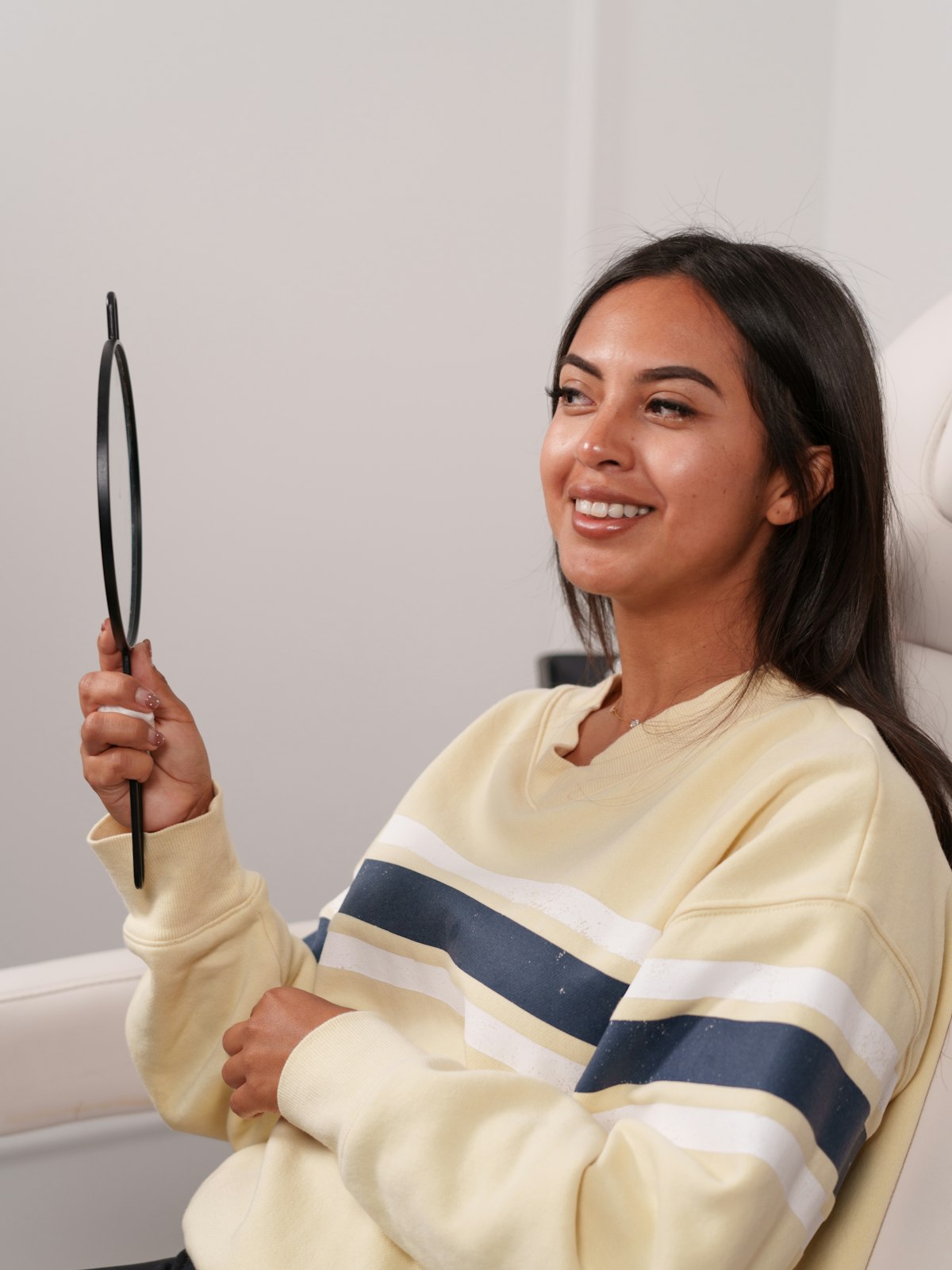 Clienta sonriente mirándose en un espejo